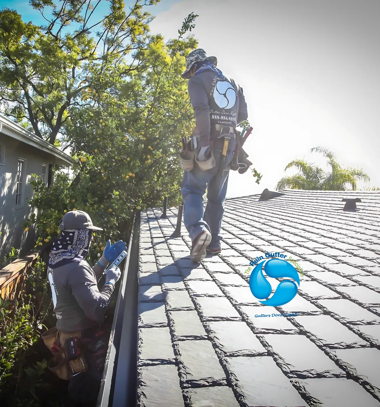 Rain Gutter Specialists technician installing gutter system on a two-story home rooftop in Los Angeles