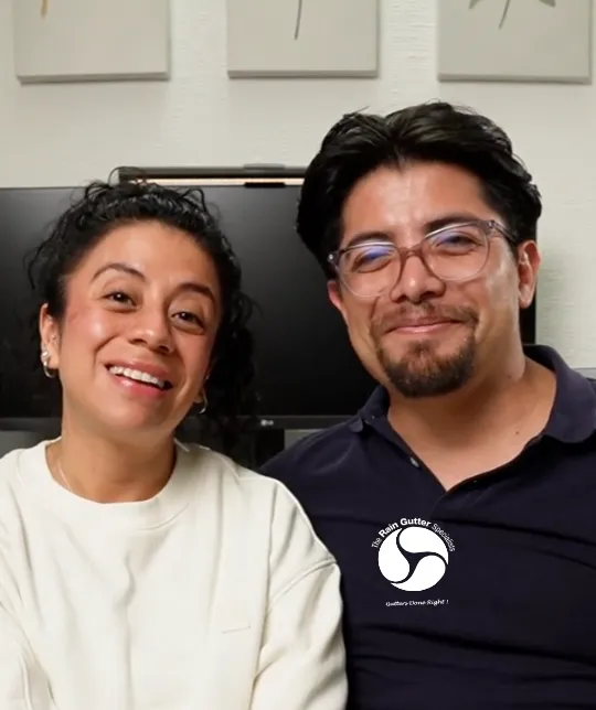 Smiling Spanish-speaking couple reviewing rain gutter install experience