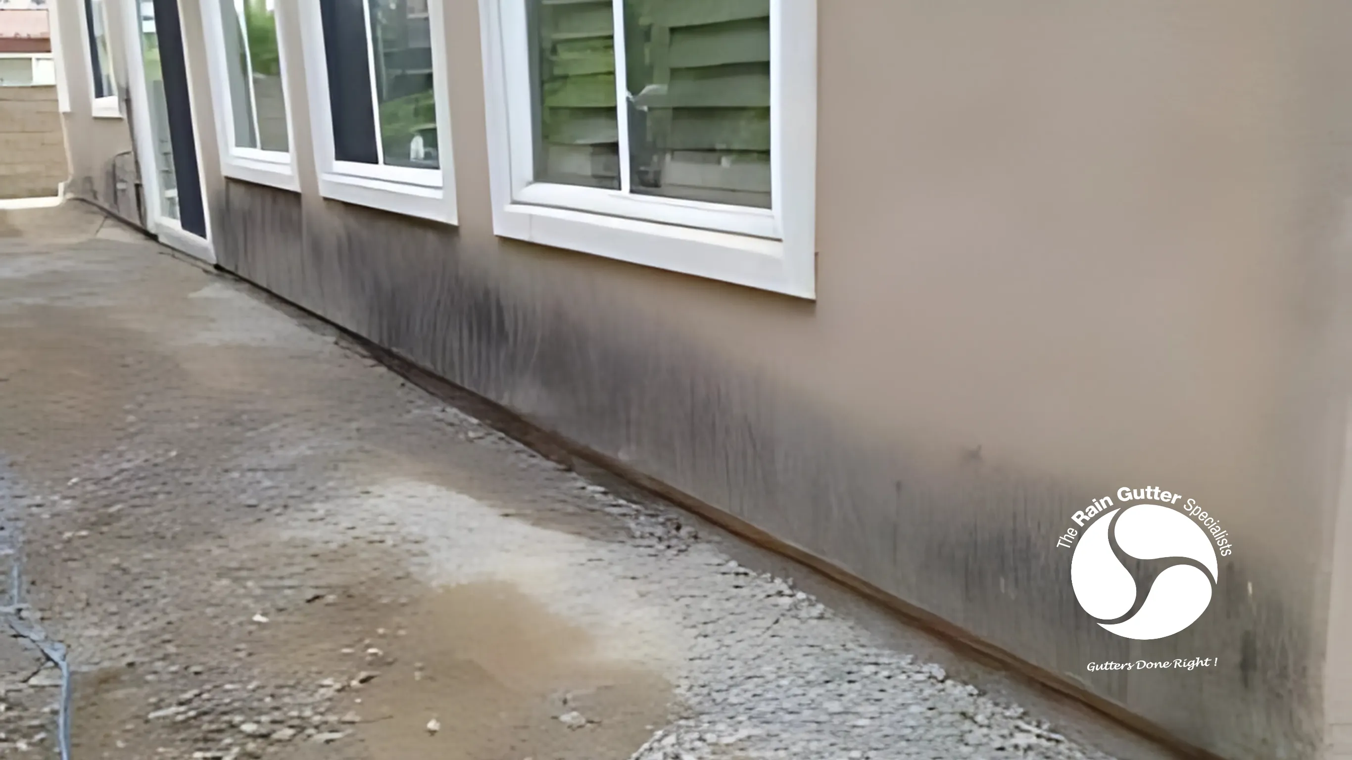 Overflowing rain gutters causing staining on siding.